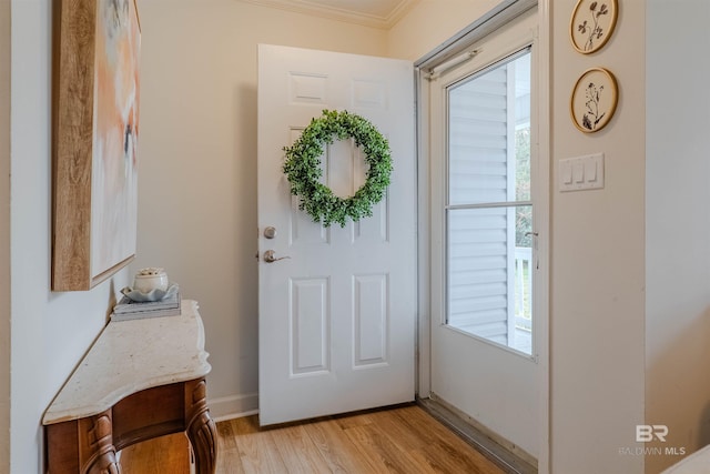 doorway to outside featuring ornamental molding and light hardwood / wood-style floors