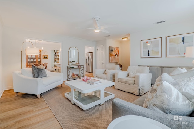 living room with ceiling fan and light hardwood / wood-style flooring