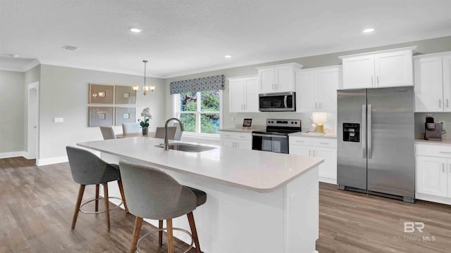 11529 Thistledown Loop, Spanish Fort, AL 36527 - kitchen featuring appliances with stainless steel finishes, a sink, wood finished floors, a kitchen island with sink, and white cabinets