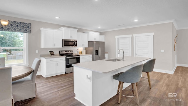 11529 Thistledown Loop, Spanish Fort, AL 36527 - kitchen with appliances with stainless steel finishes, a sink, an island with sink, wood finished floors, and a kitchen bar