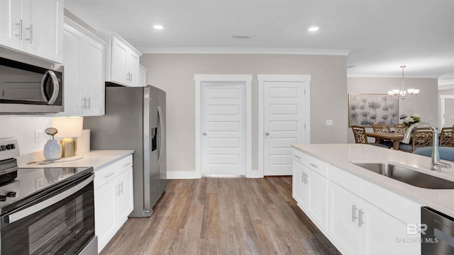 11529 Thistledown Loop, Spanish Fort, AL 36527 - kitchen featuring stainless steel appliances, a sink, crown molding, a chandelier, and wood finished floors