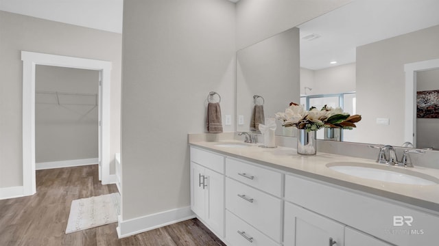 11529 Thistledown Loop, Spanish Fort, AL 36527 - bathroom with double vanity, wood finished floors, a walk in closet, a shower, and baseboards