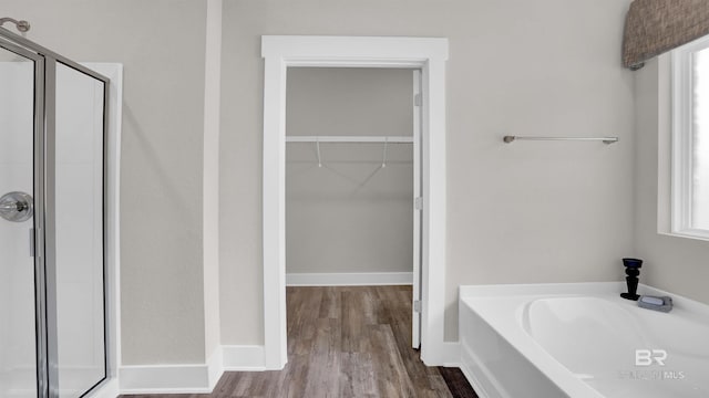 11529 Thistledown Loop, Spanish Fort, AL 36527 - bathroom with a stall shower, a spacious closet, a bath, wood finished floors, and baseboards