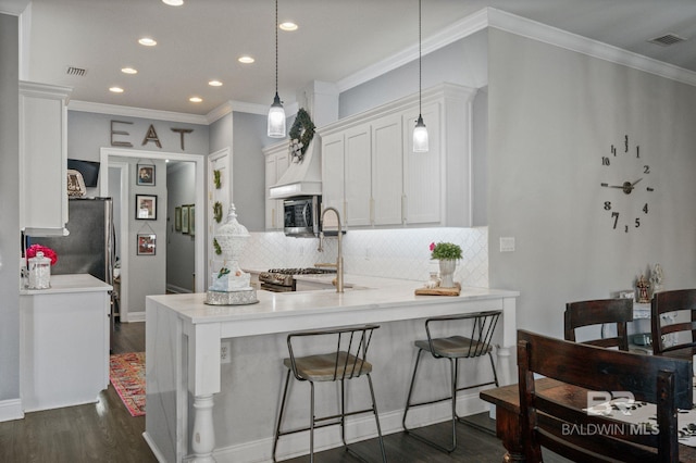 kitchen with visible vents, dark wood finished floors, stainless steel microwave, and white cabinetry