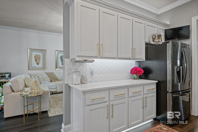 kitchen with ornamental molding, stainless steel fridge, dark wood finished floors, and tasteful backsplash