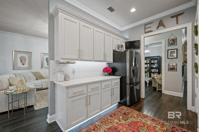 kitchen featuring tasteful backsplash, stainless steel fridge, visible vents, ornamental molding, and light countertops