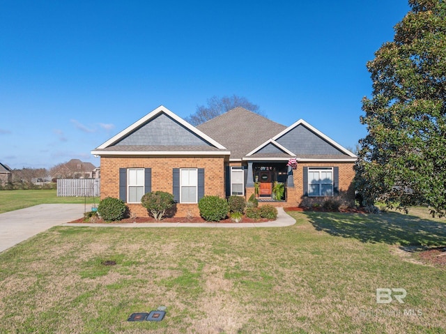 view of front of home with a front lawn, fence, and brick siding