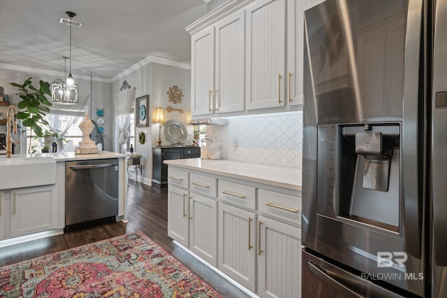 kitchen with dark wood-type flooring, light countertops, ornamental molding, appliances with stainless steel finishes, and tasteful backsplash