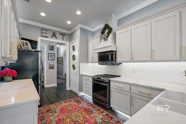 kitchen with stainless steel appliances, backsplash, dark wood finished floors, and crown molding