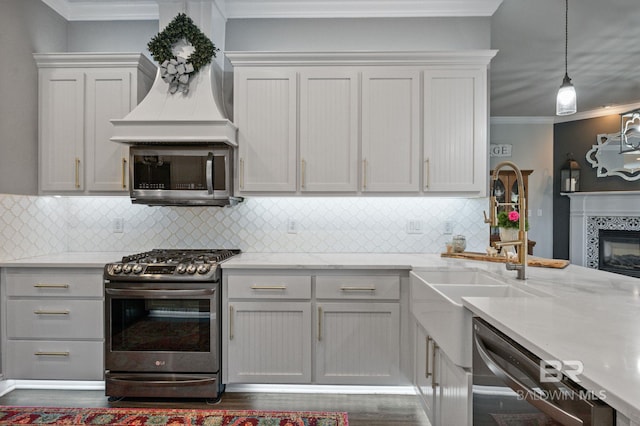 kitchen with crown molding, a fireplace, backsplash, appliances with stainless steel finishes, and premium range hood