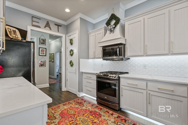 kitchen with dark wood finished floors, ornamental molding, stainless steel appliances, and backsplash