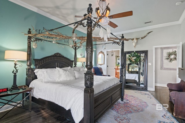 bedroom with ornamental molding, visible vents, baseboards, and wood finished floors