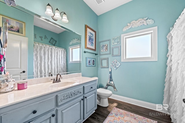 bathroom featuring toilet, wood finished floors, visible vents, vanity, and baseboards