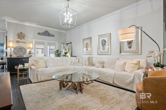 living room featuring a notable chandelier, ornamental molding, wood finished floors, and french doors