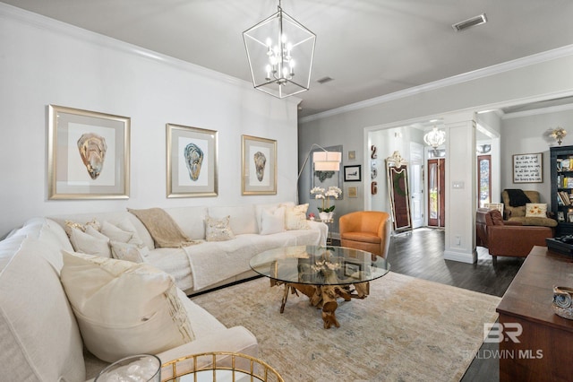 living room featuring a notable chandelier, visible vents, dark wood-type flooring, and ornamental molding