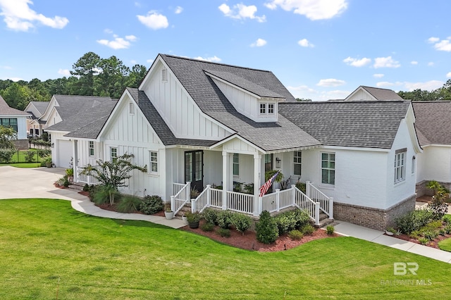 back of property with covered porch and a lawn