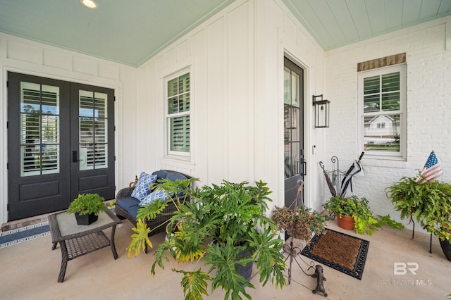 view of exterior entry featuring brick siding and french doors