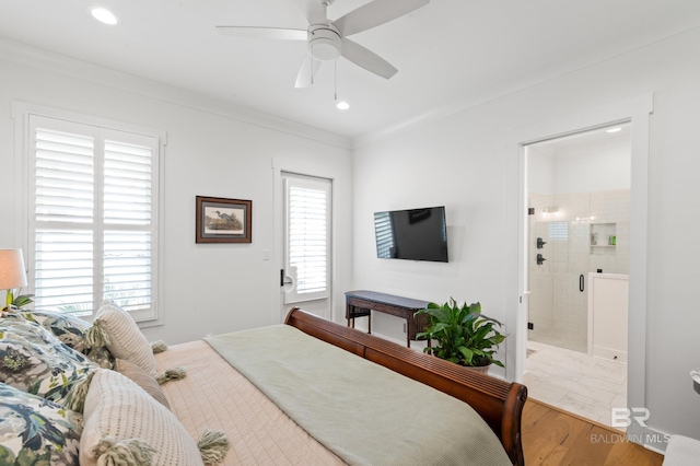 bedroom with multiple windows, ensuite bath, hardwood / wood-style flooring, and ceiling fan