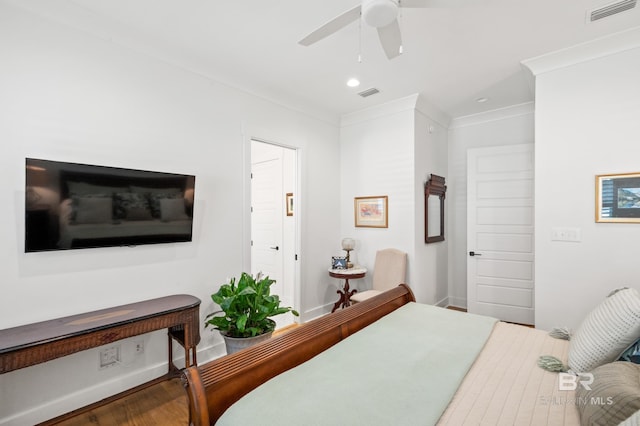 bedroom with ornamental molding, hardwood / wood-style floors, and ceiling fan