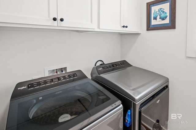 laundry room featuring washer and clothes dryer and cabinets