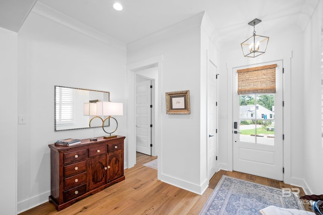 foyer entrance featuring light wood-type flooring, ornamental molding, recessed lighting, baseboards, and a chandelier