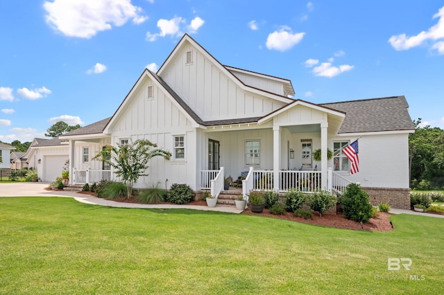 view of front of property with covered porch, a garage, and a front lawn