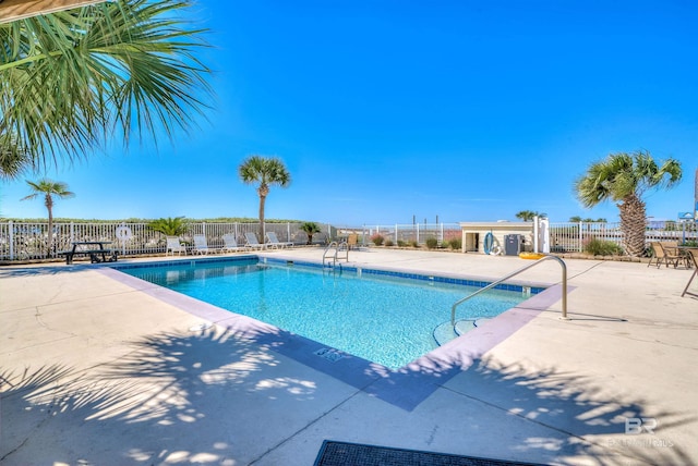 pool with a patio area and fence