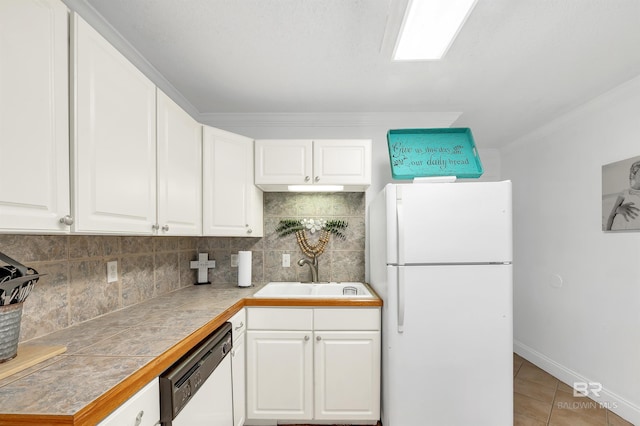 kitchen featuring decorative backsplash, white cabinets, a sink, and white appliances