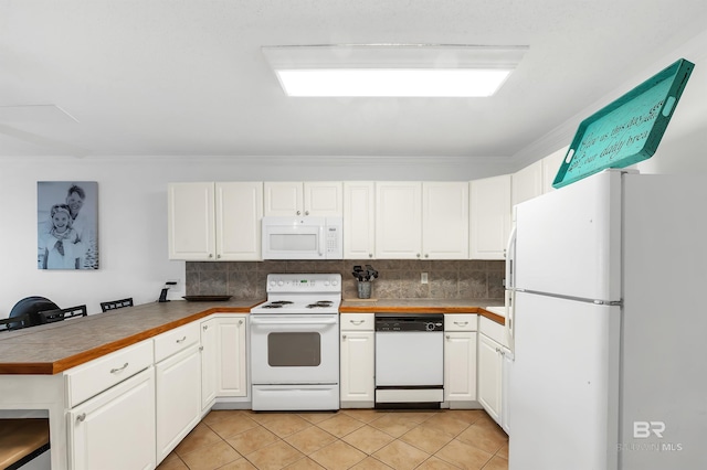 kitchen featuring white appliances, light tile patterned floors, decorative backsplash, white cabinets, and a peninsula