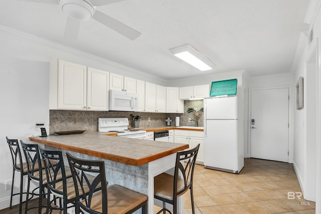 kitchen featuring a breakfast bar area, white appliances, backsplash, white cabinets, and a peninsula