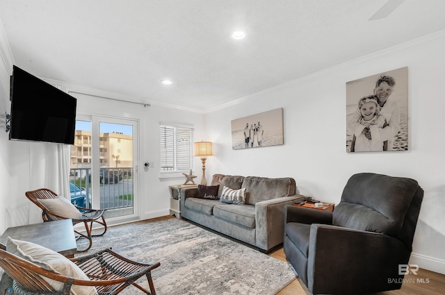 living room featuring baseboards, wood finished floors, recessed lighting, and crown molding