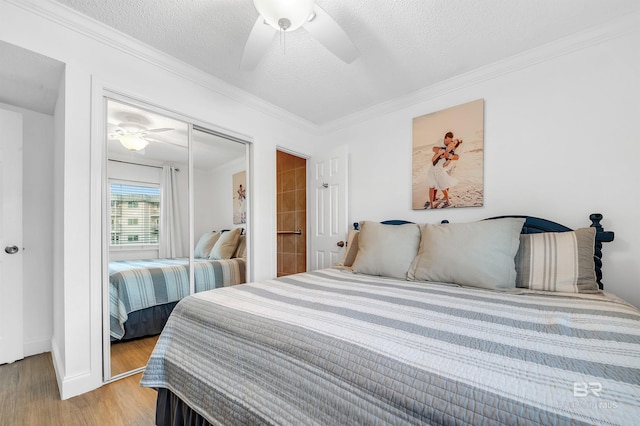 bedroom featuring light wood-type flooring, a closet, ornamental molding, and a textured ceiling