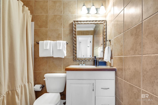 full bath featuring toilet, vanity, and tile walls
