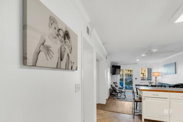 kitchen with crown molding, white cabinetry, butcher block counters, visible vents, and ceiling fan