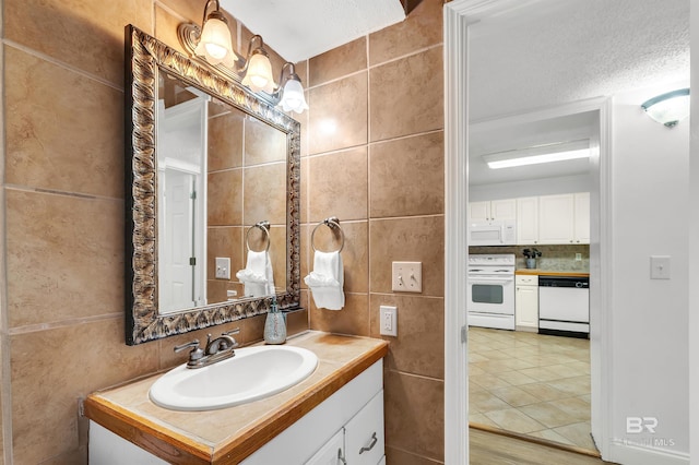 bathroom featuring tile walls, backsplash, tile patterned flooring, and vanity