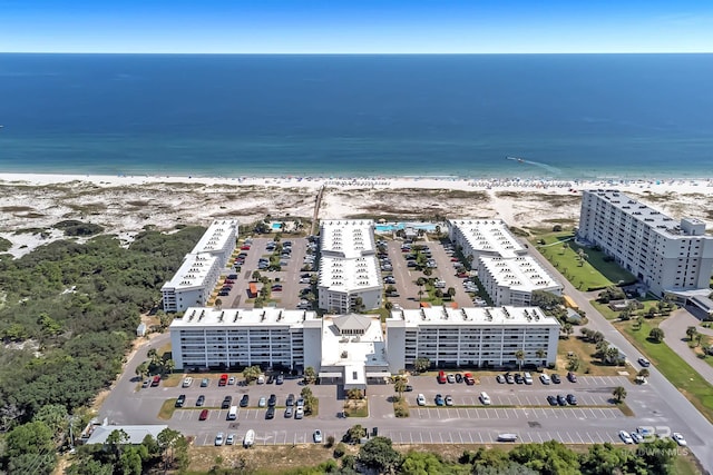 birds eye view of property featuring a water view and a beach view