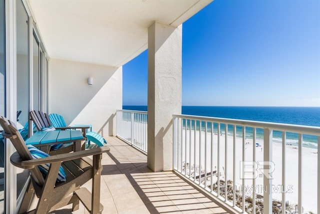 balcony with a water view and a view of the beach