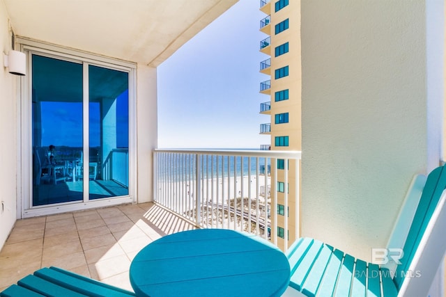 balcony featuring a water view and a beach view