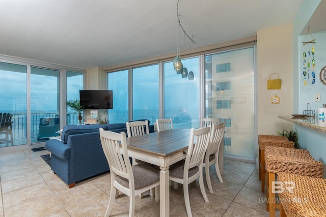 tiled dining area featuring floor to ceiling windows