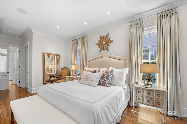 bedroom with recessed lighting, crown molding, baseboards, and wood finished floors