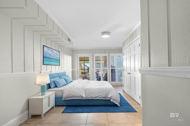 bedroom featuring light tile patterned floors and crown molding