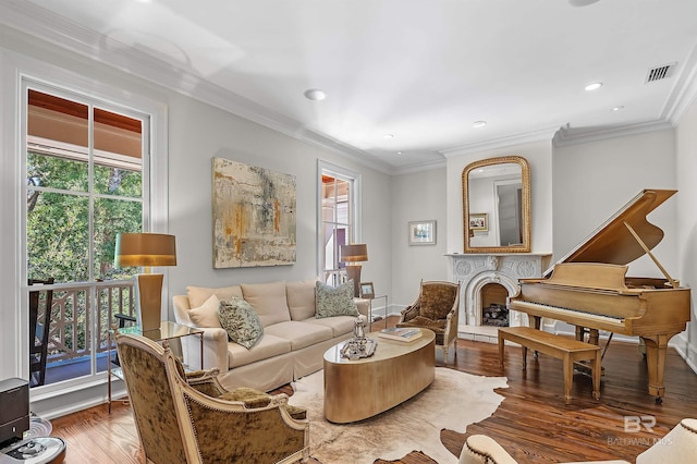 sitting room with ornamental molding, a wealth of natural light, and wood finished floors