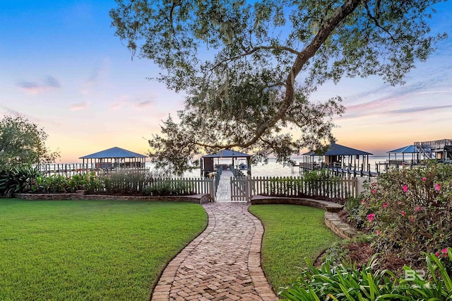 view of property's community featuring fence and a lawn