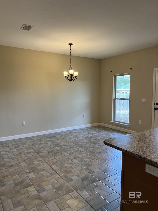 spare room with an inviting chandelier