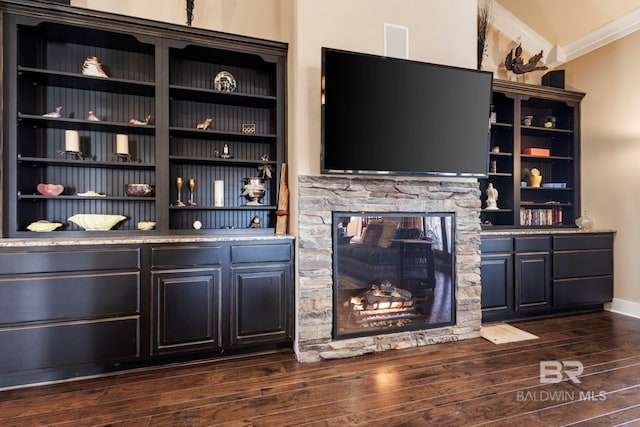 bar featuring lofted ceiling, a fireplace, dark wood-type flooring, and ornamental molding