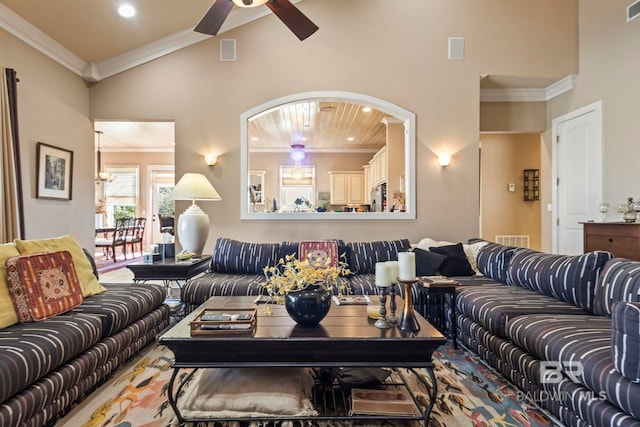 living area featuring visible vents, high vaulted ceiling, ceiling fan, and ornamental molding