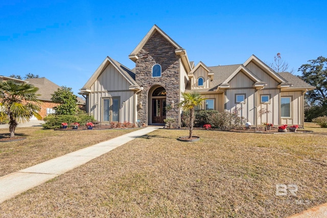 view of front facade with stone siding, board and batten siding, a shingled roof, and a front lawn