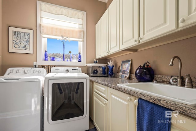 washroom with a sink, cabinet space, and washer and dryer