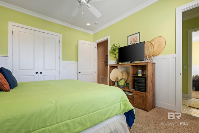 bedroom with crown molding, ceiling fan, light colored carpet, and a closet