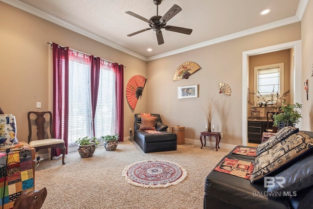 carpeted living room with ornamental molding and ceiling fan